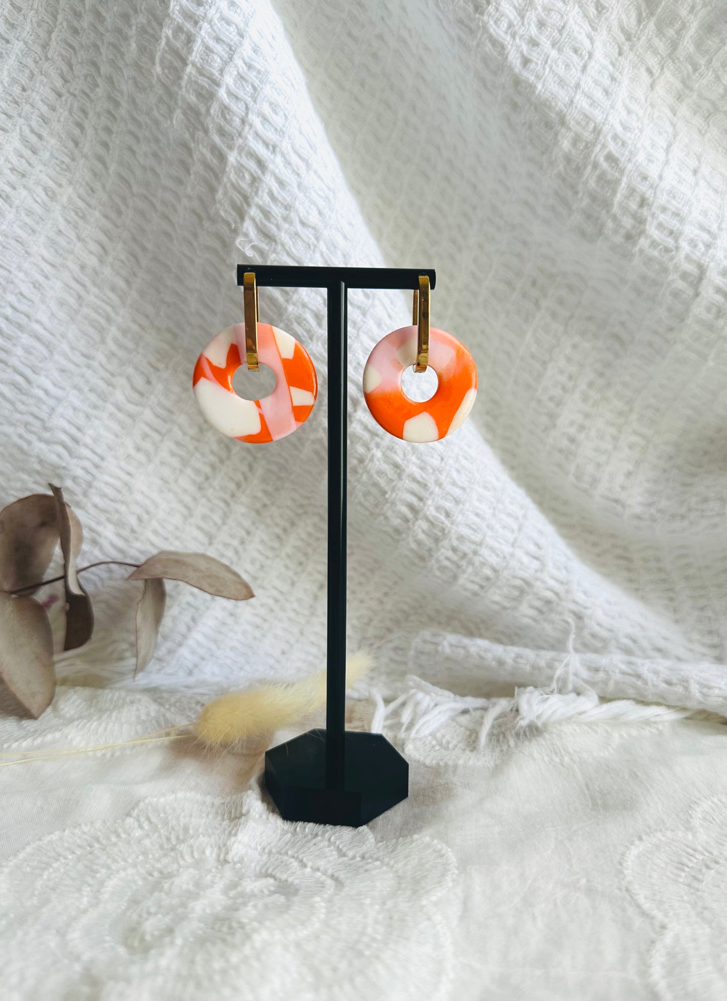 Pendiente donut grande, aro alargado, tono naranja, blanco y rosado.