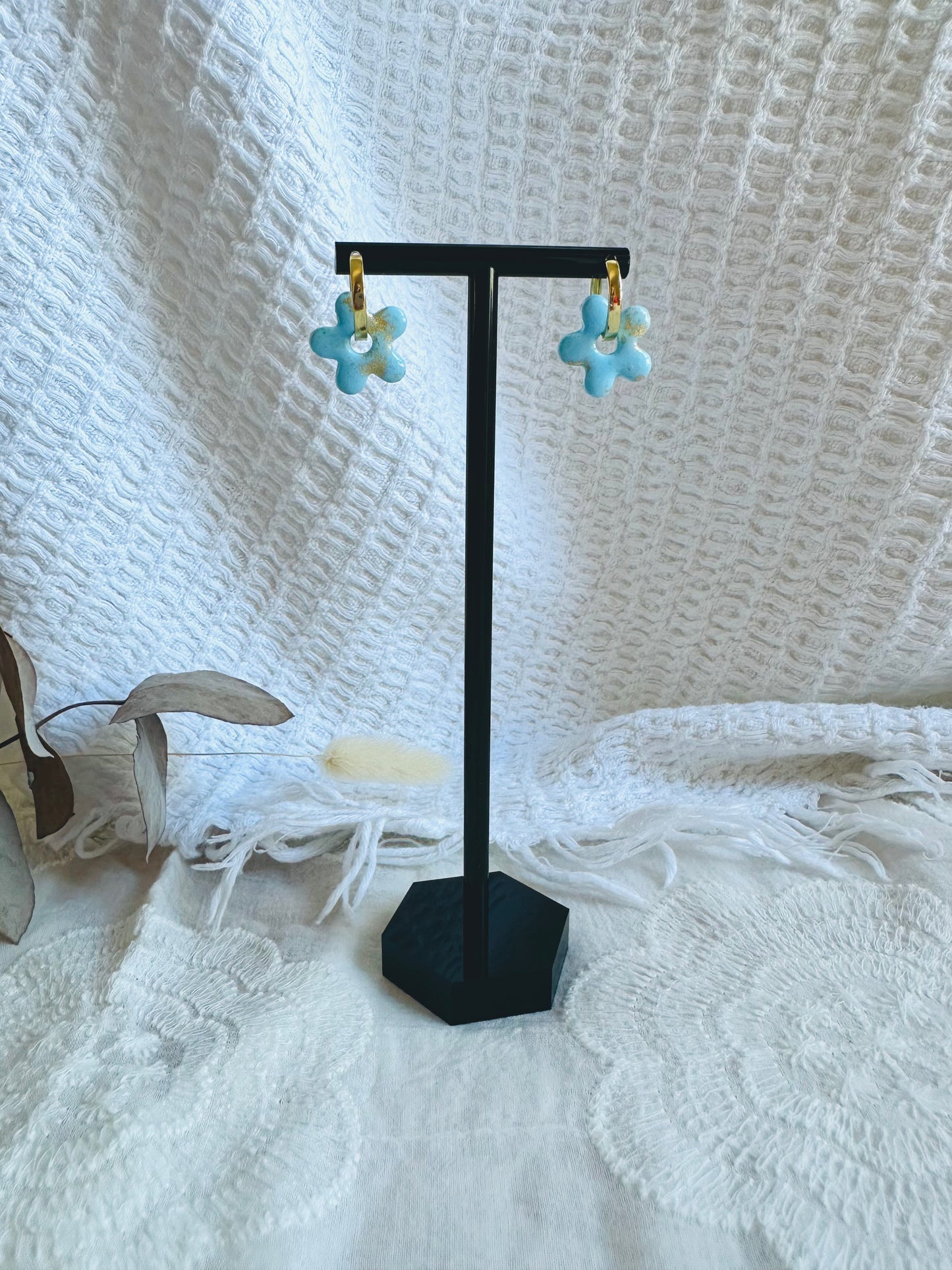 Pendiente flor con aro pequeño, en color azul clarito con toques dorados.