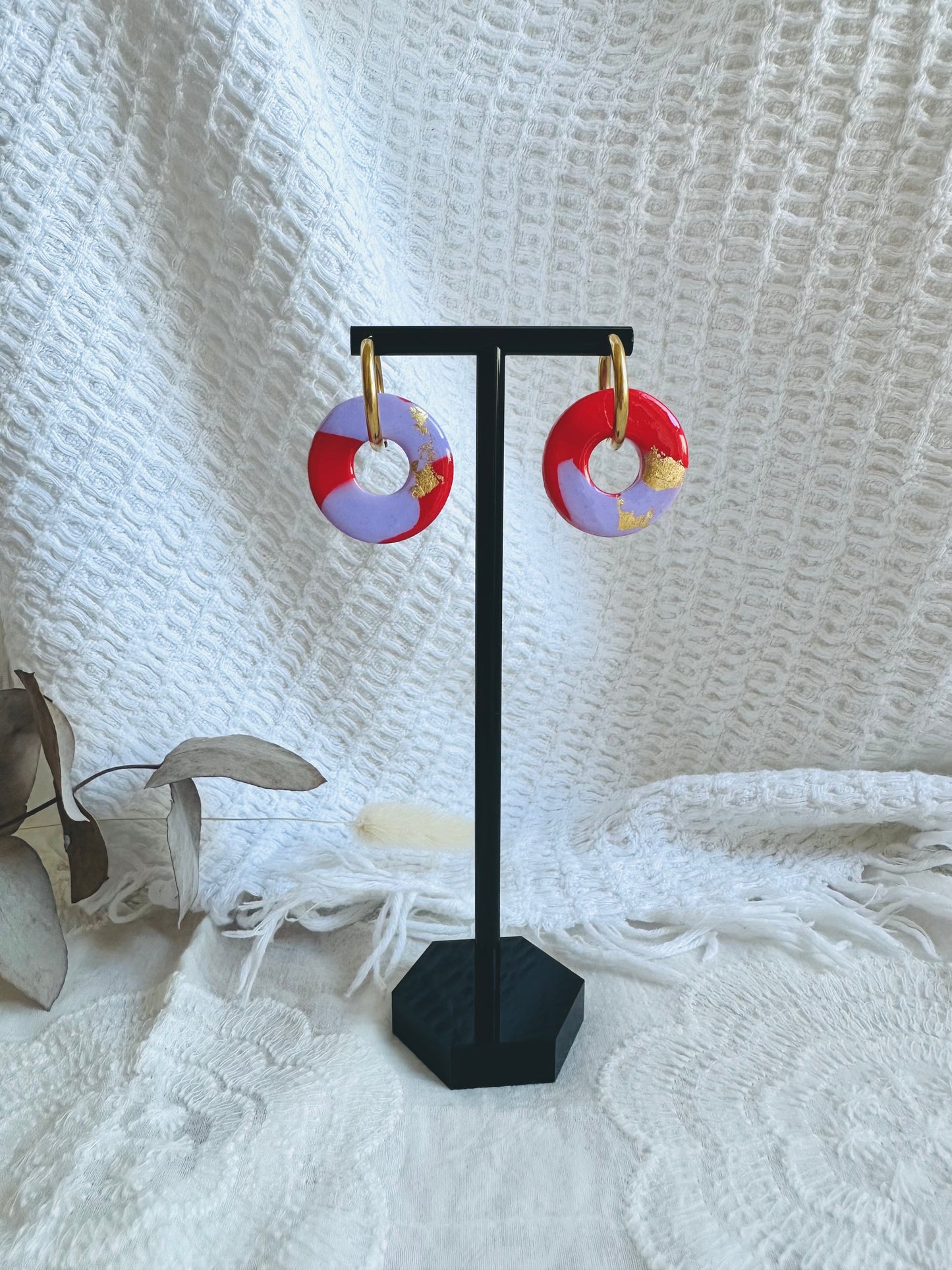 Pendiente donut mediano con aro, en tono lila , rojo y toques dorados.
