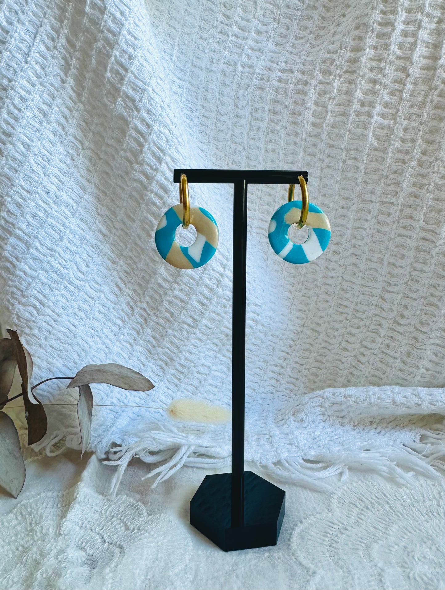 Pendiente donut mediano con aro, en tono blanco, beige y azulón.