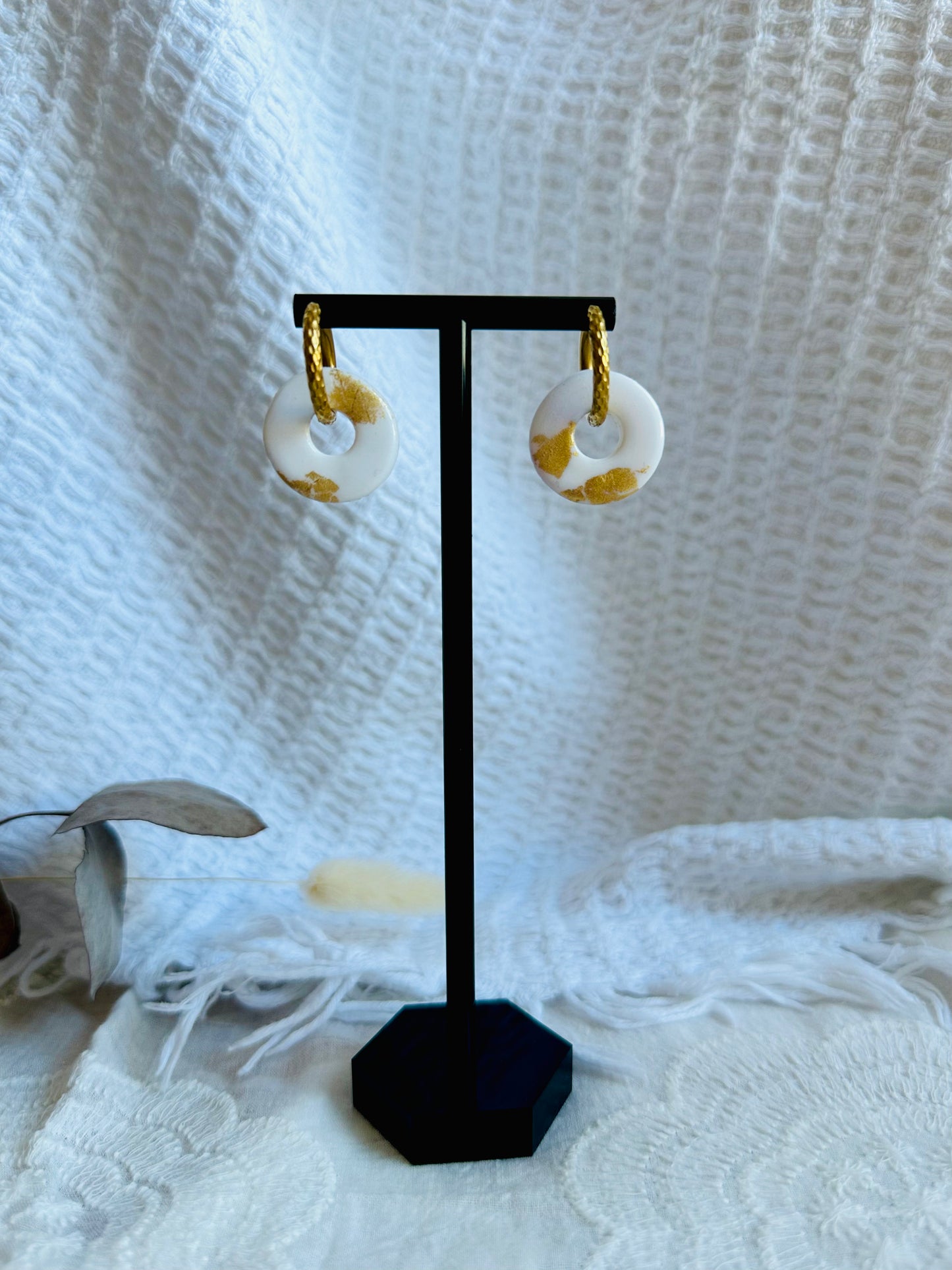 Pendiente donut mediano con aro (con relieve), en color blanco.