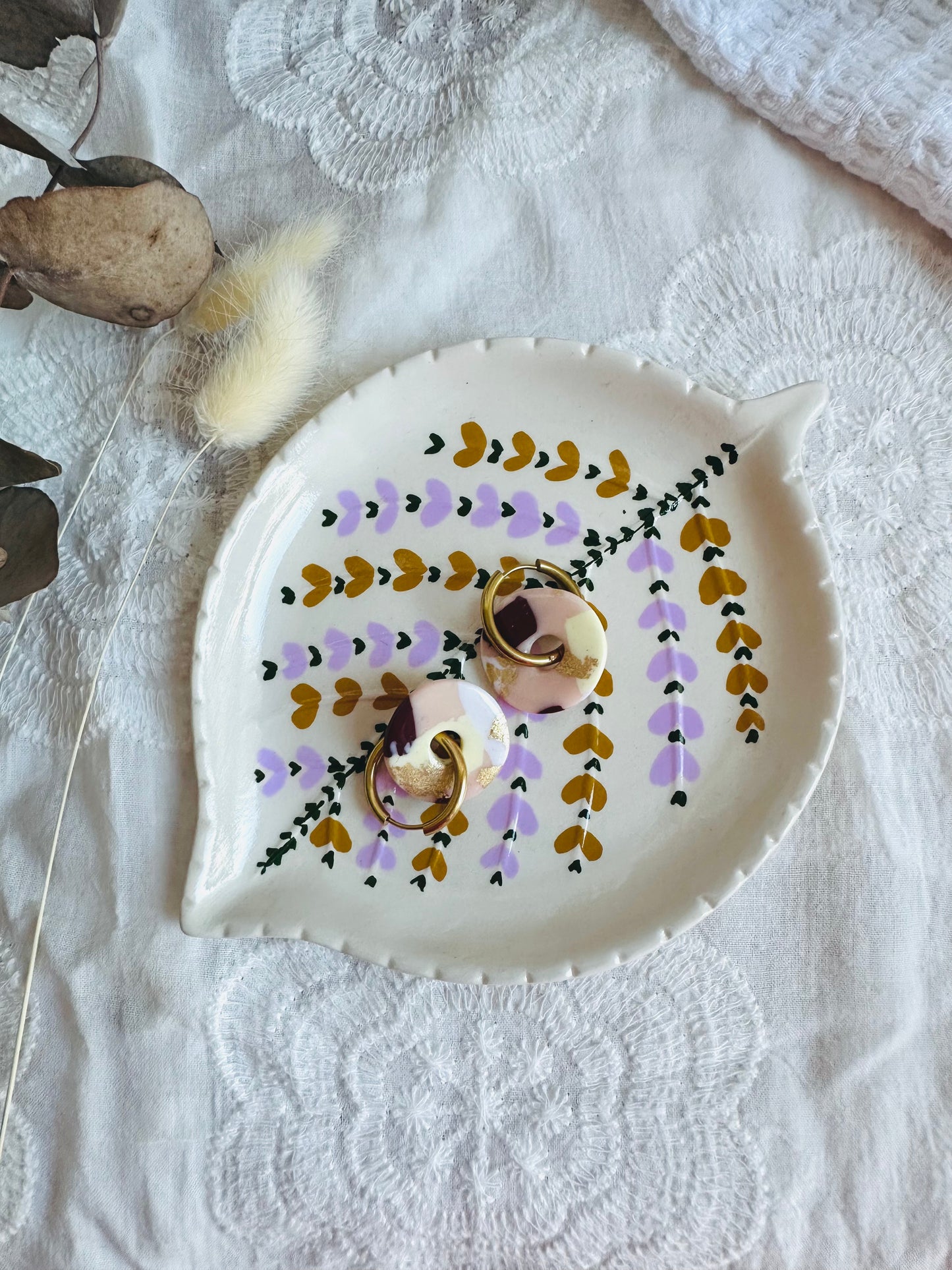 Pendiente donut mediano con aro, en tono blanco, beige, granate y toques dorados.