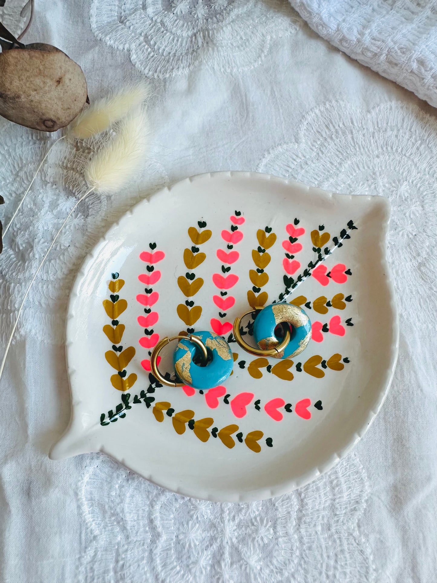 Pendiente donut mediano con aro, en tono azulón con toques dorados.