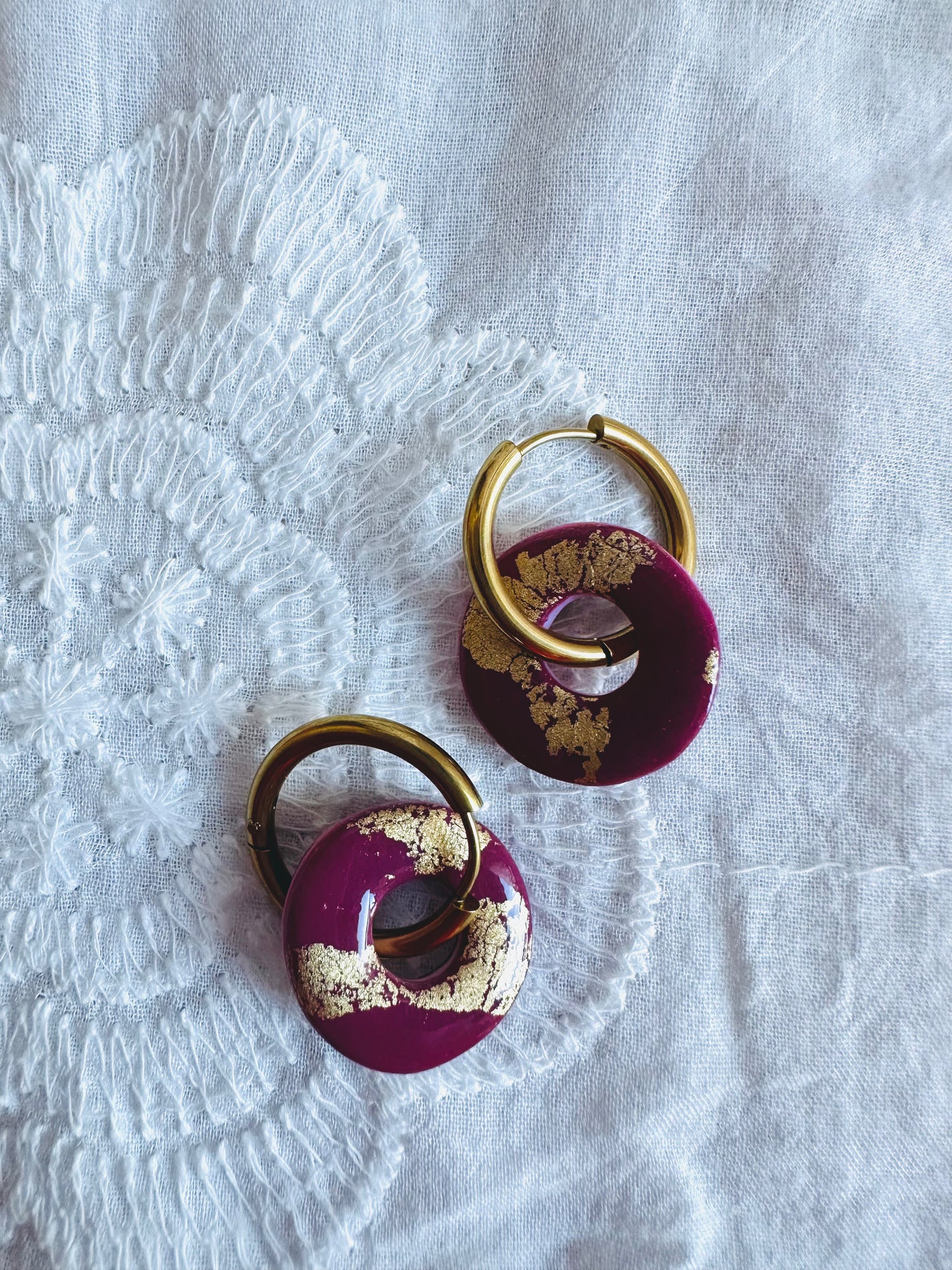Pendiente donut mediano con aro, en tono granate.