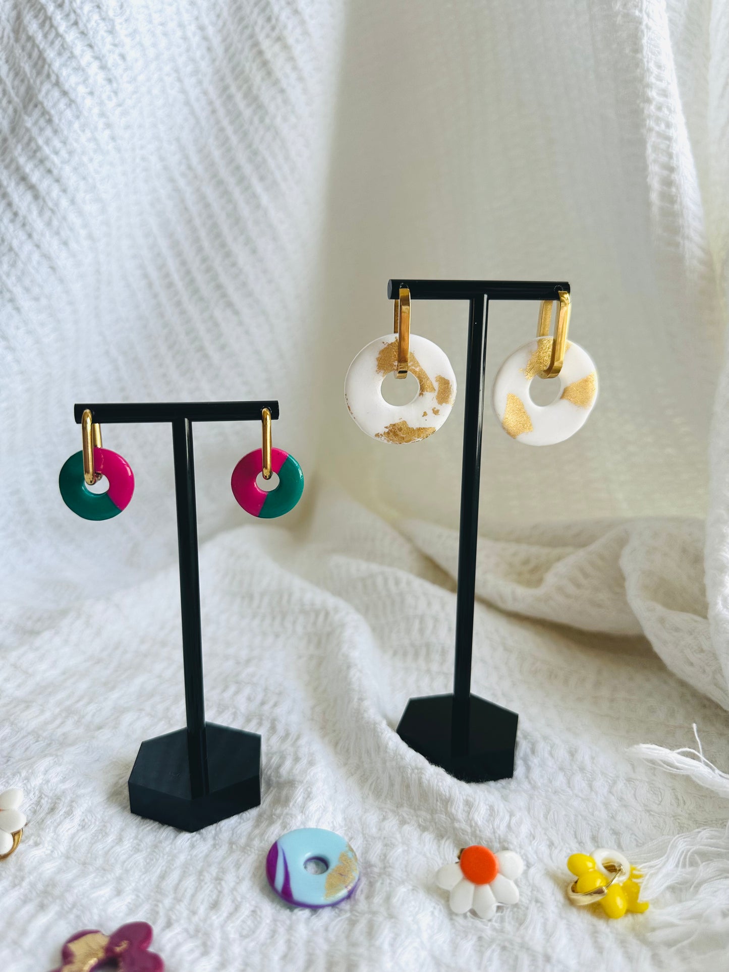 Pendiente donut grande, aro alargado, blanco con toques dorados.