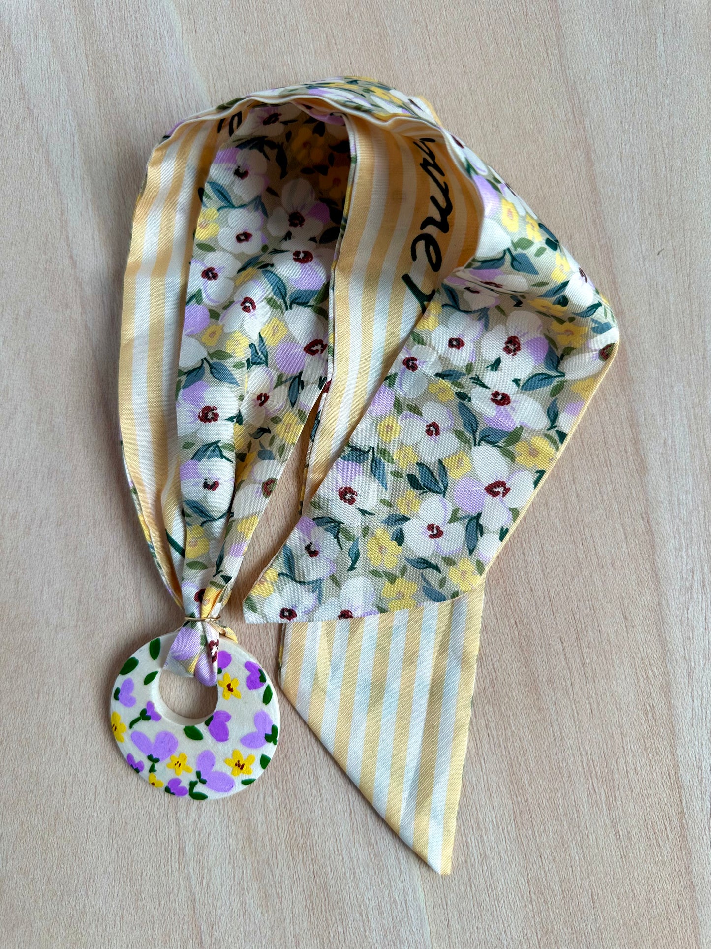 Adorno para bolso amarillo con flores lilas y blancas (con agujero).