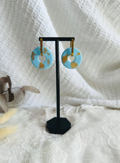 Pendiente donut grande, aro alargado, azul bebé con toques dorados.