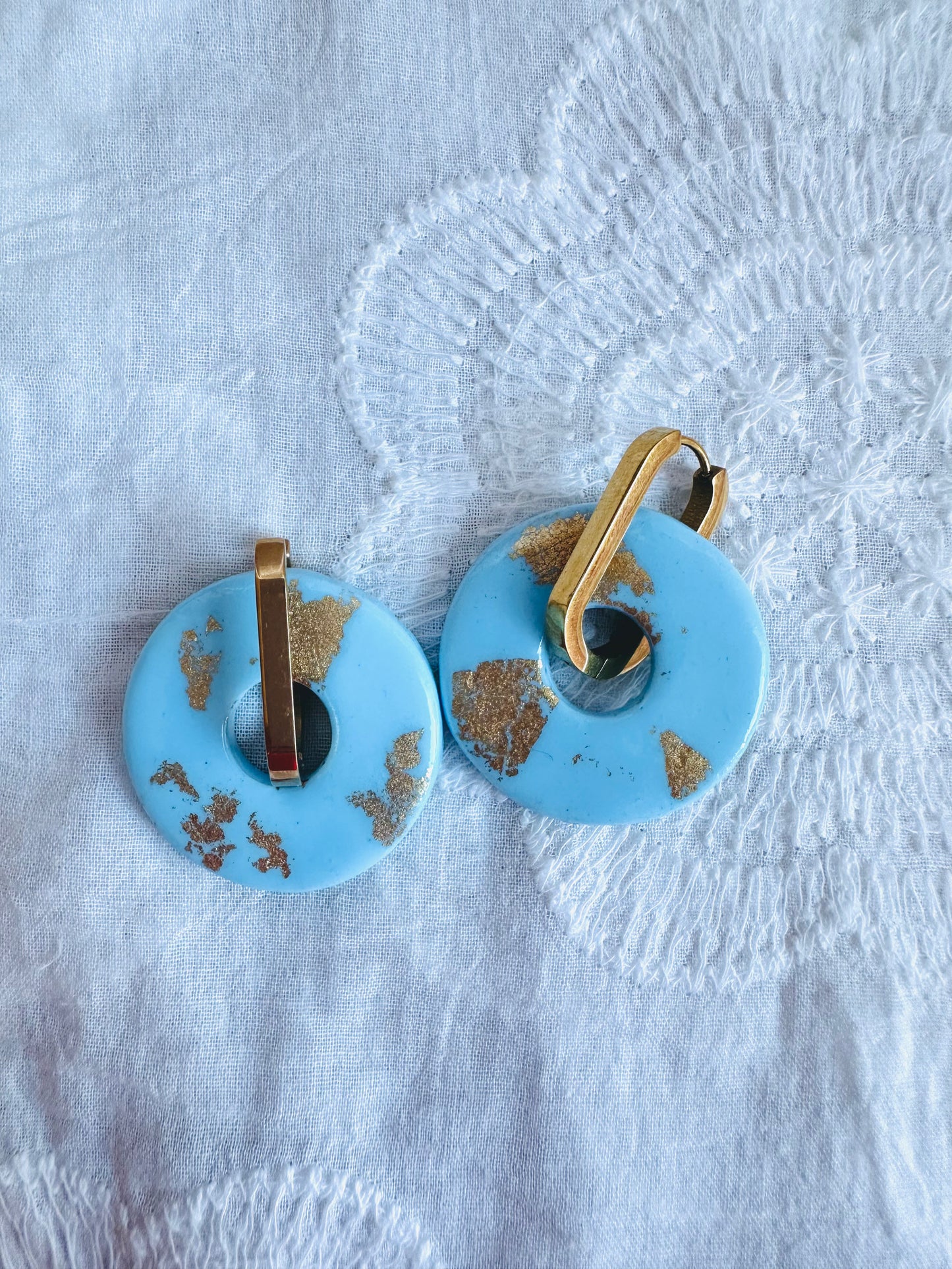 Pendiente donut grande, aro alargado, azul bebé con toques dorados.