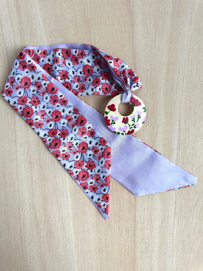 Adorno para bolso flores rojas y fondo lila (con agujero).
