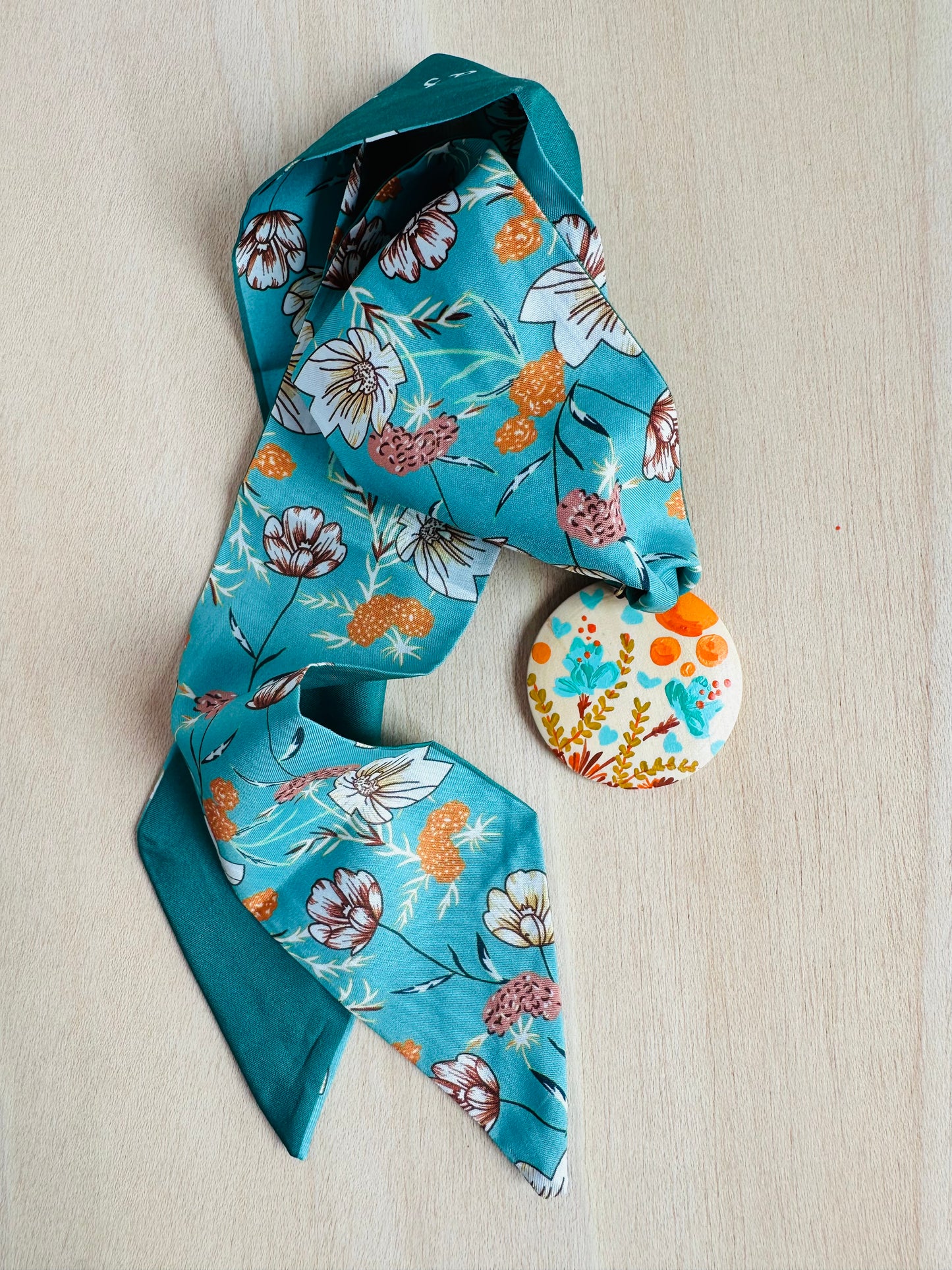 Adorno para bolso turquesa con medallón flores silvestres.