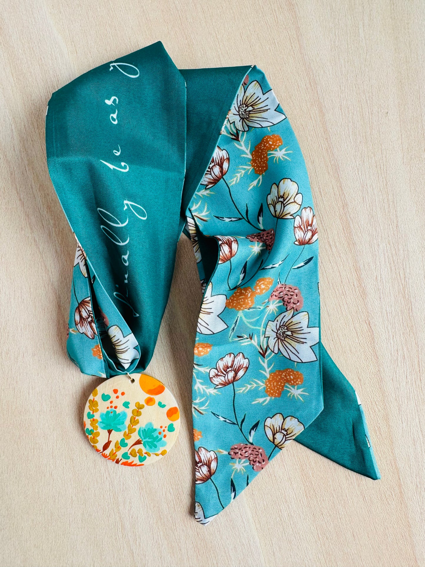 Adorno para bolso turquesa con medallón flores silvestres.