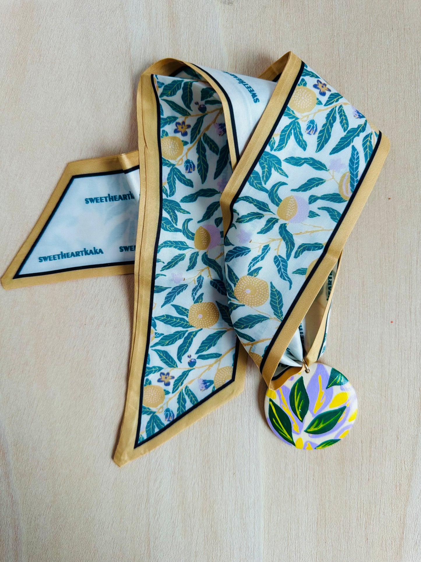 Adorno para bolso hojitas verdes y flores amarillas.