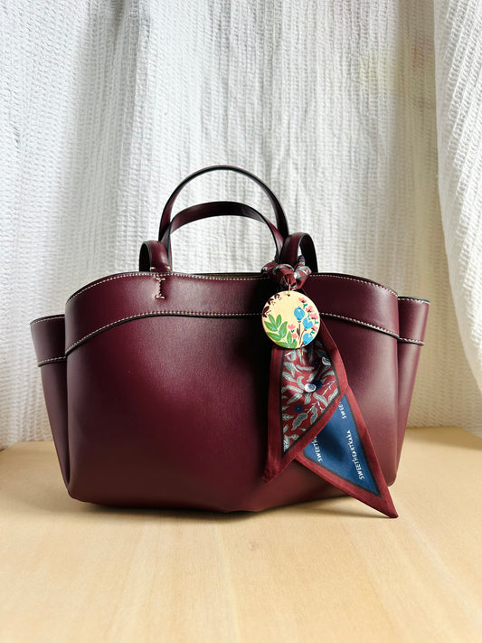 Adorno para bolso granate.