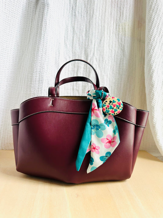Adorno para bolso con flores turquesas y rosas.