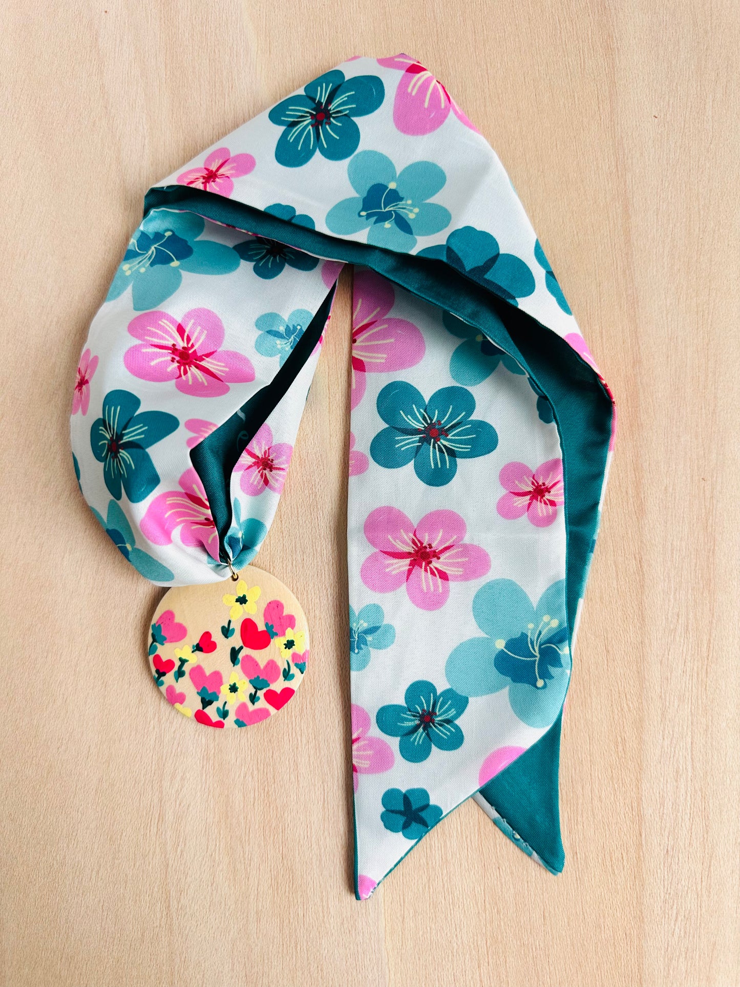 Adorno para bolso con flores turquesas y rosas.