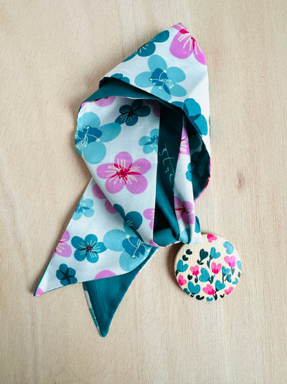 Adorno para bolso con flores turquesas y rosas.