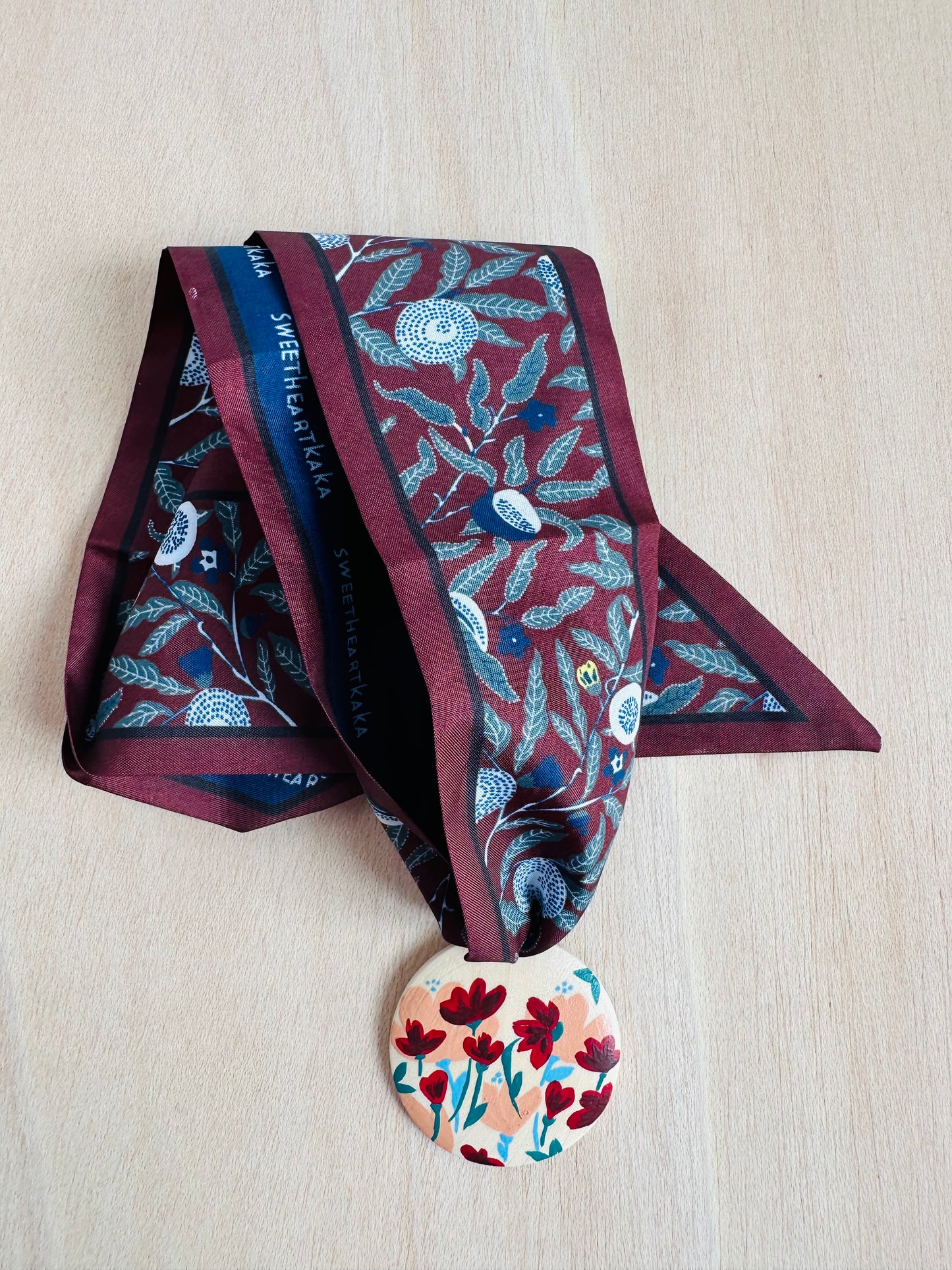Adorno para bolso granate.