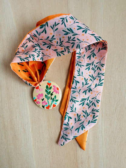 Adorno para bolso rosa con hojitas verdes.