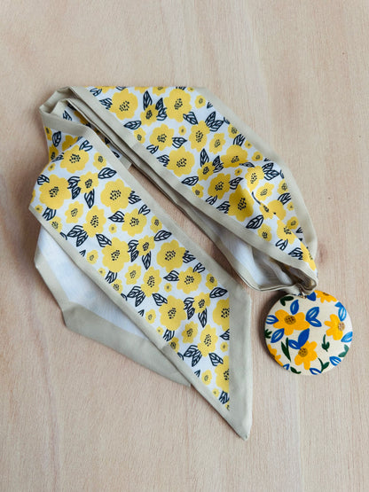 Adorno para bolso con flores amarillas.